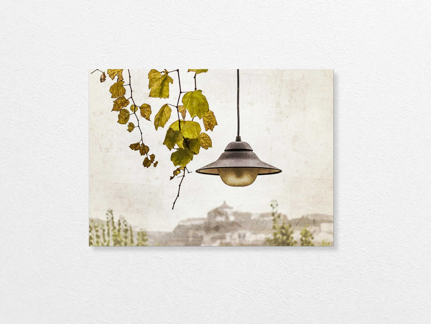 Light bulb hanging above with a view of Porto in the background, featuring trees and buildings.