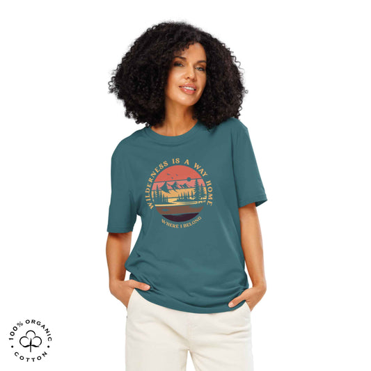 Woman wearing Eco-friendly t-shirt in organic cotton, stargazer, with graphic featuring a nature theme: mountains, trees, sun and the bold phrase “wild nature is the way home, where I belong”.