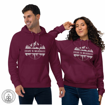 Happy outdoorsy man and woman wearing burgundy eco-friendly hoodies featuring forest, mountain and compass design and 'Escape to Wilderness' graphic text  on a white background.