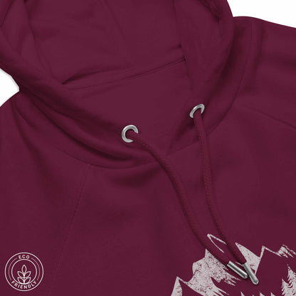 Close-up burgundy eco-friendly hoodie featuring forest, mountain and compass design and 'escape to wilderness' graphic text on a white background