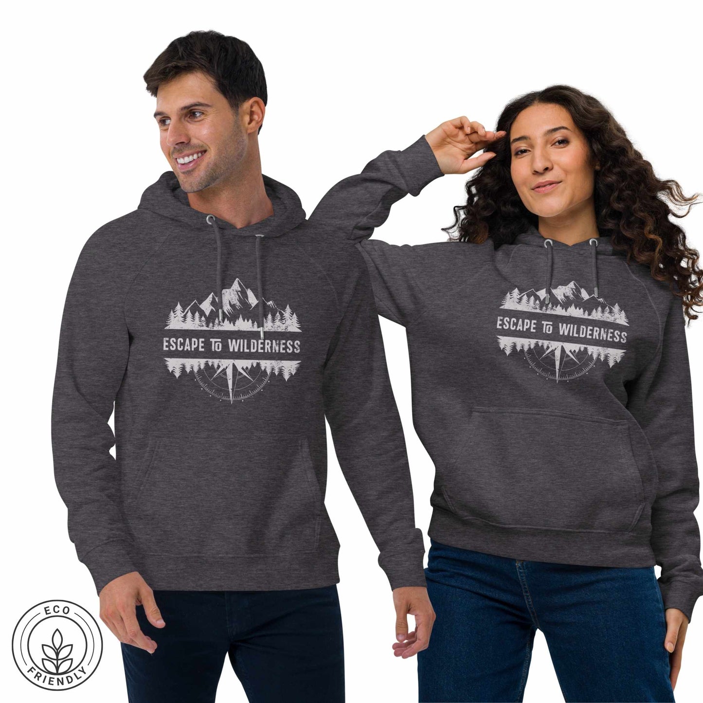 Happy outdoorsy man and woman wearing dark gray eco hoodies with forest, mountain and compass design and 'Escape to Wilderness' text graphic on a white background.