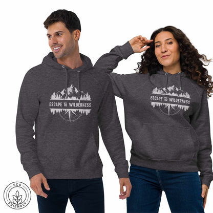 Happy outdoorsy man and woman wearing dark gray eco hoodies with forest, mountain and compass design and 'Escape to Wilderness' text graphic on a white background.