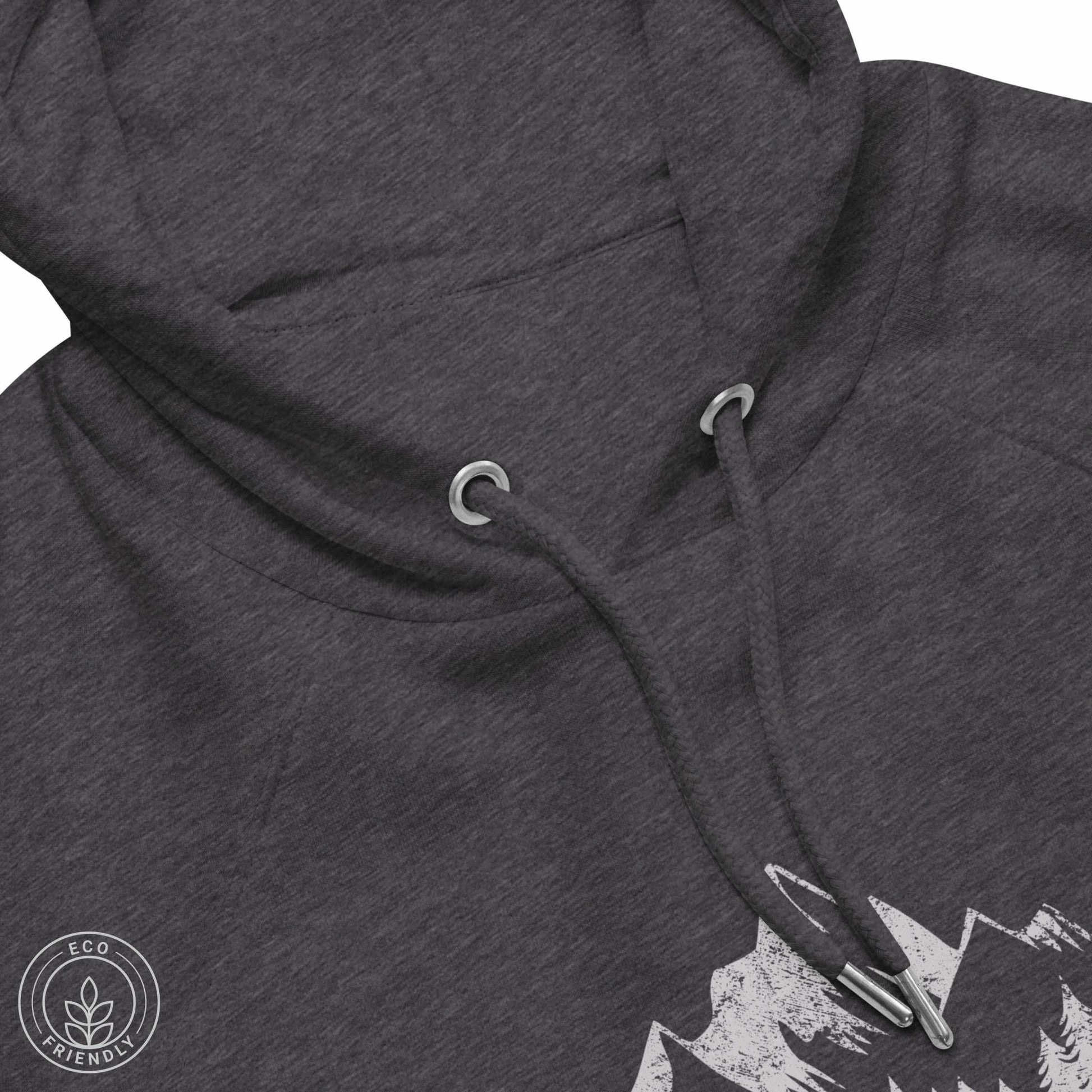 Close-up Dark gray eco hoodie with mountain design and 'escape to wilderness' graphic text on a white background