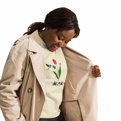 Happy Woman wearing a beige trench coat with a rose sweatshirt with floral design featuring tulips and hummingbird on a white background