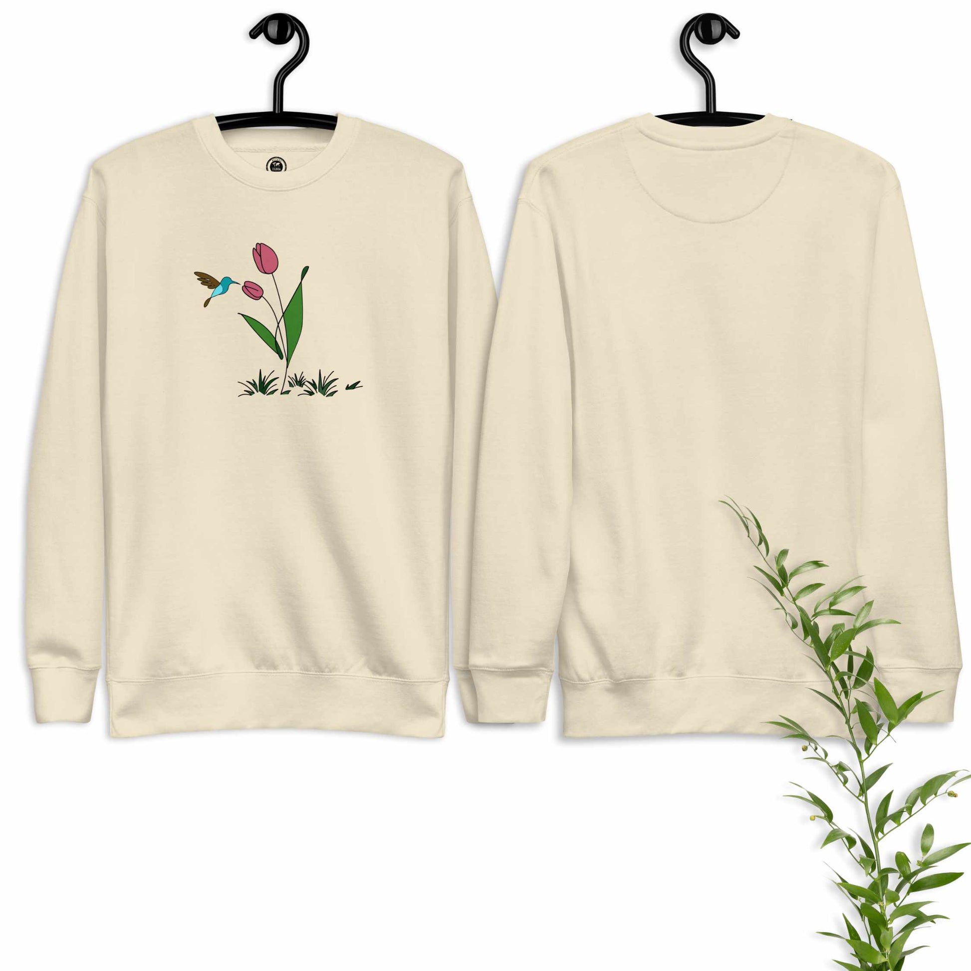 Beige sweatshirt with floral design featuring tulips and hummingbird on a white background