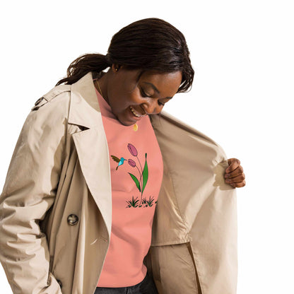 Happy Woman wearing a beige trench coat over a rose sweatshirt with floral design featuring tulip and hummingbird on a white background