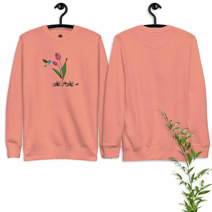 Rose sweatshirt with floral design featuring tulip and hummingbird on a hanger against a white background