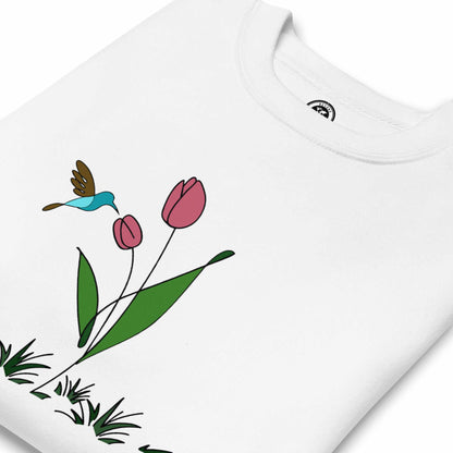 Folded White sweatshirt with a floral design featuring tulips and a hummingbird on a white background.