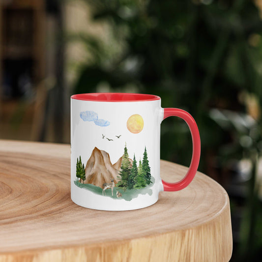 white and red Ceramic Mug  11oz featuring a nature scene with trees, mountains, and a deer in a natural background and wood table