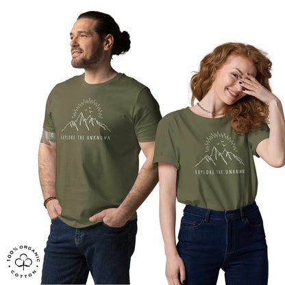 happy man and woman wearing khaki organic cotton t-shirt with mountain, sun and birds graphic and 'Explore the Unknown' text on a white background.
