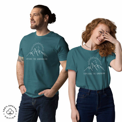 happy man and woman wearing stargazer organic cotton t-shirt with mountain, sun and birds graphic and 'Explore the Unknown' text on a white background.