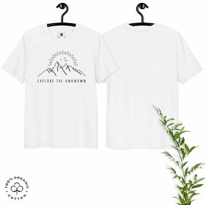 White organic cotton t-shirt with mountain, sun and birds graphic and 'Explore the Unknown' text on hangers, with a plant on a white background.
