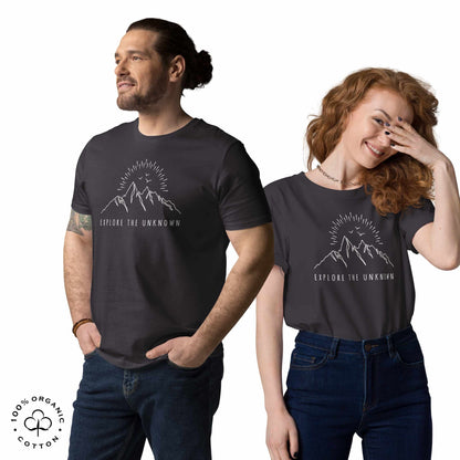 happy man and woman wearing Anthracite organic cotton t-shirt with mountain, sun and birds graphic and 'Explore the Unknown' text on a white background.