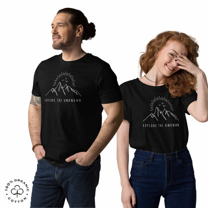 happy man and woman wearing black organic cotton t-shirt with mountain, sun and birds graphic and 'Explore the Unknown' text  on a white background.