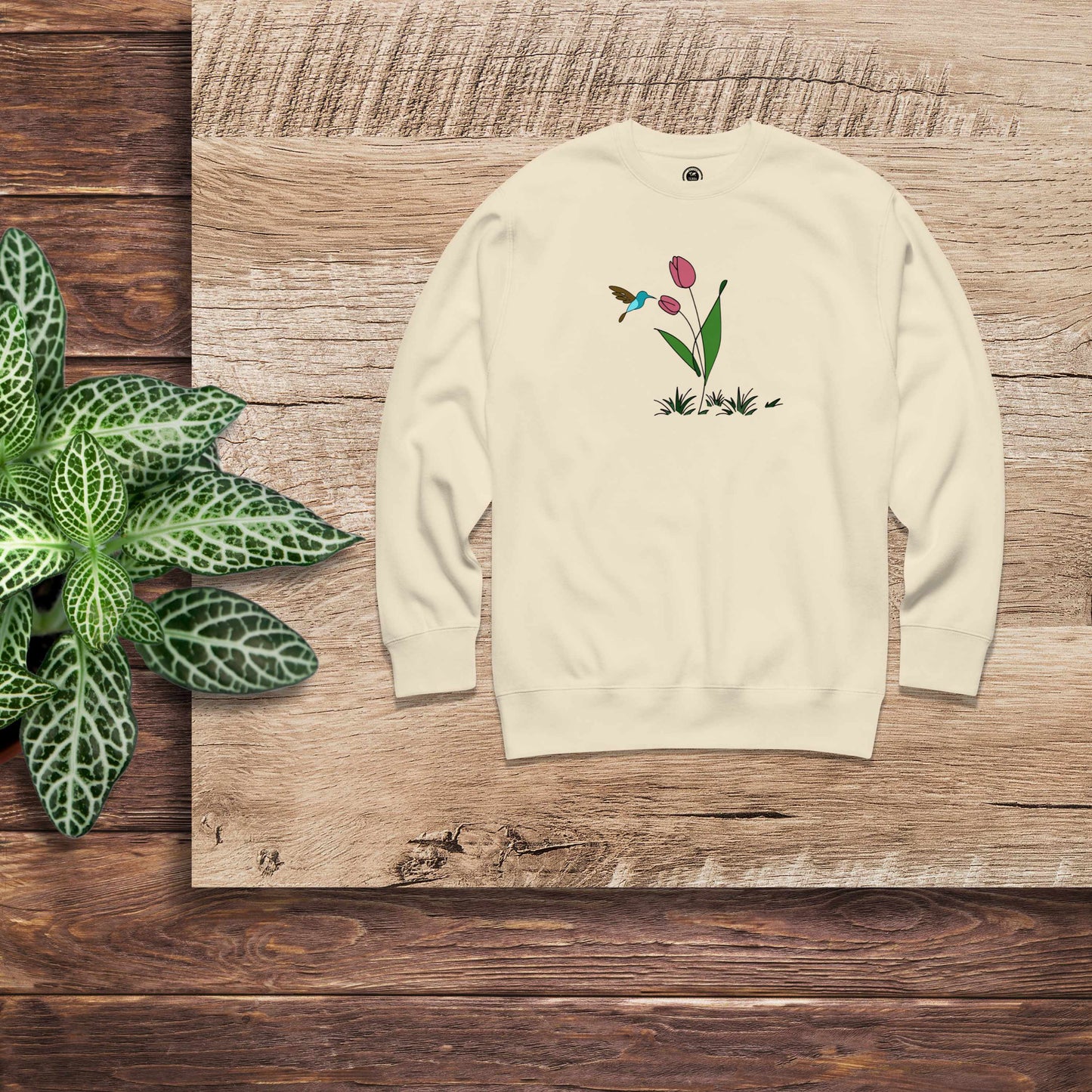 Fresh Feeling design captures a fleeting moment of harmony. Beige sweatshirt with a floral, hummingbird and tulip design. 