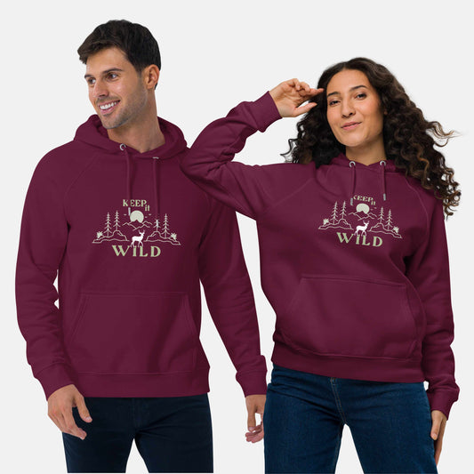 Man and woman wearing burgundy eco hoodie with 'Keep it Wild' bold and deer, mountain, forest graphic design