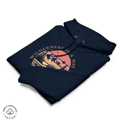 Folded navy organic cotton hoodie with nature-themed graphic, mountain, forest, sun and river. With bold Wilderness is a way home, where I belong. 