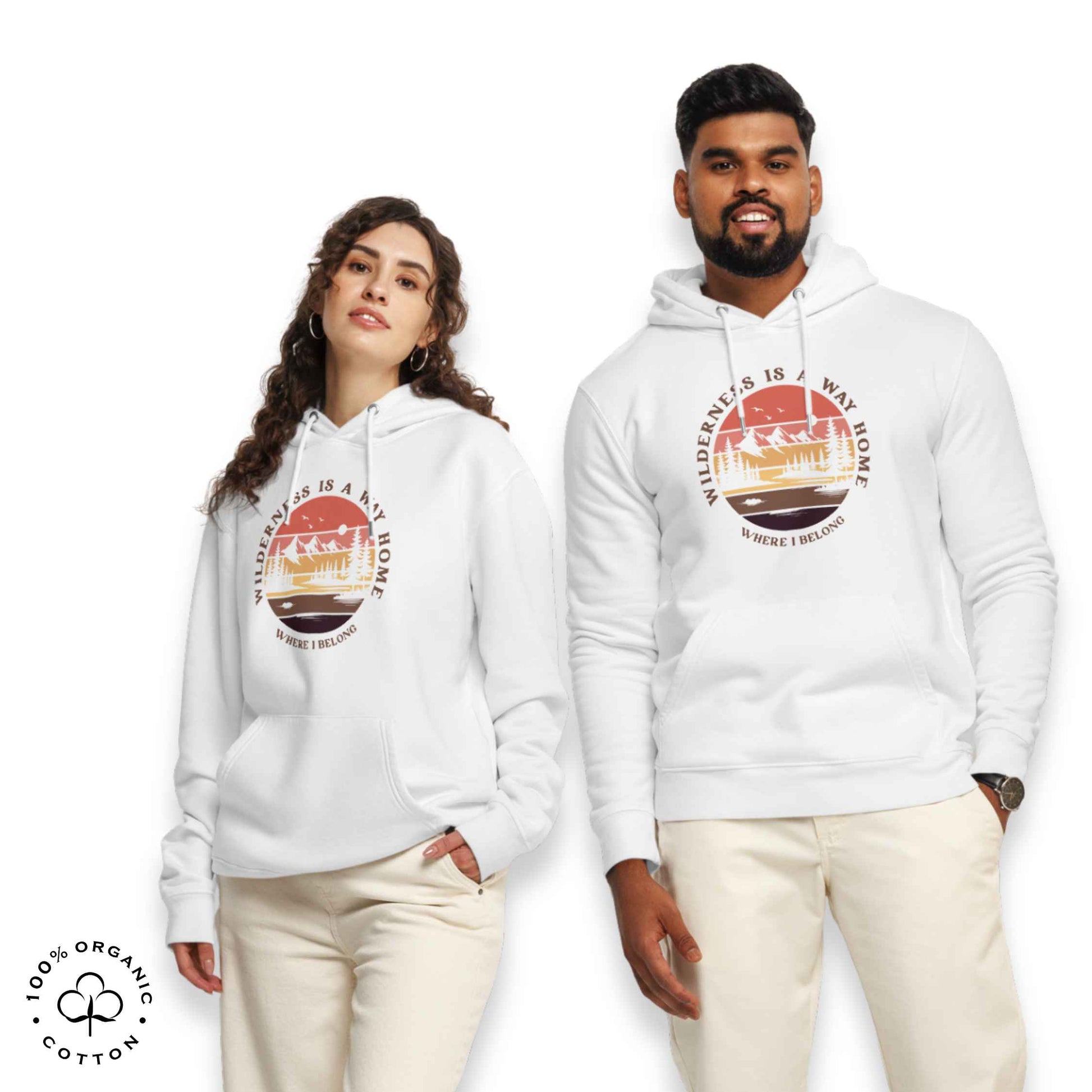 Woman and men wearing white organic cotton hoodie with nature-themed graphic, mountain, forest, sun and river. With bold Wilderness is a way home, where I belong. 