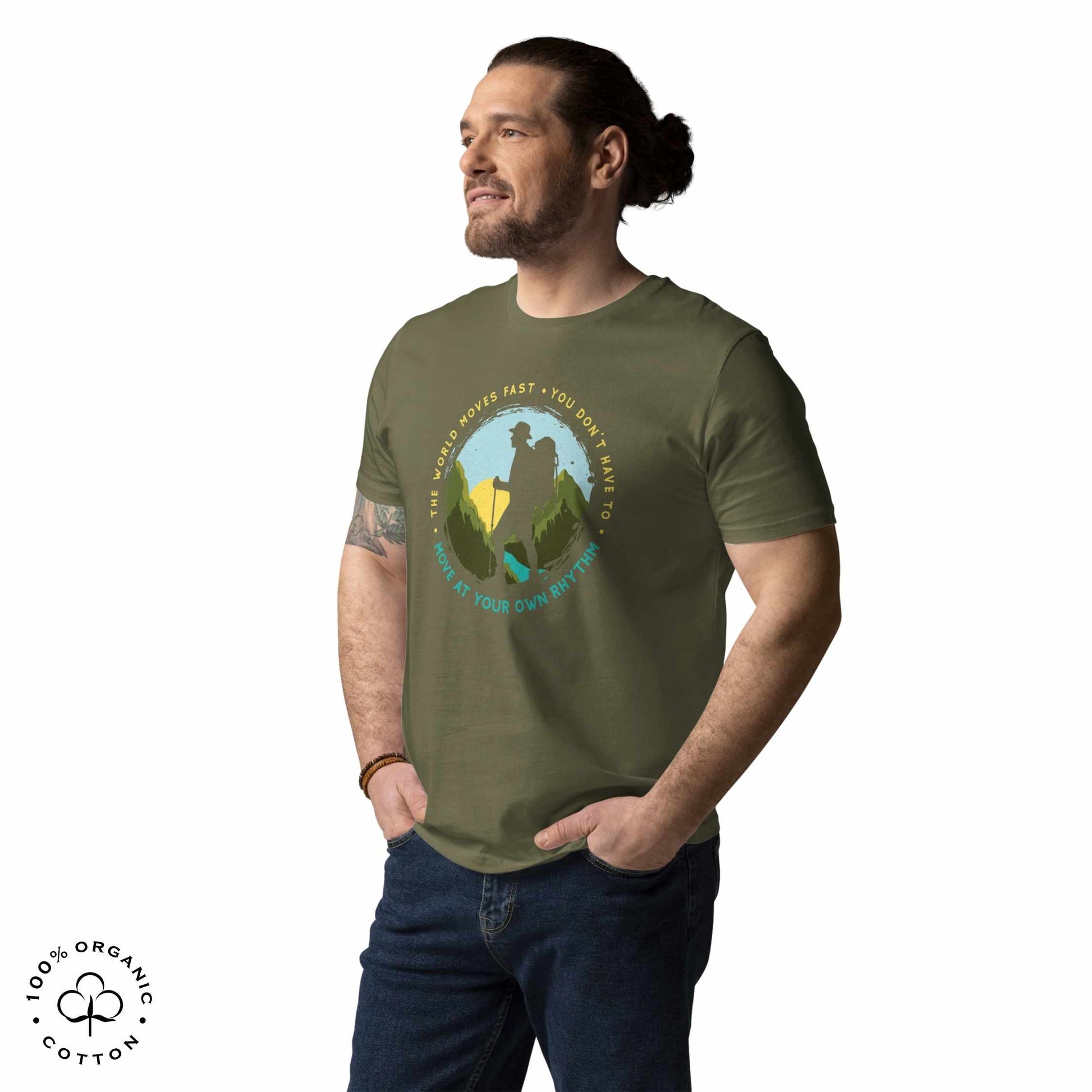 Man wearing Khaki organic cotton t-shirt with a hiking graphic design and text "Move at your own rhythm" on a white background