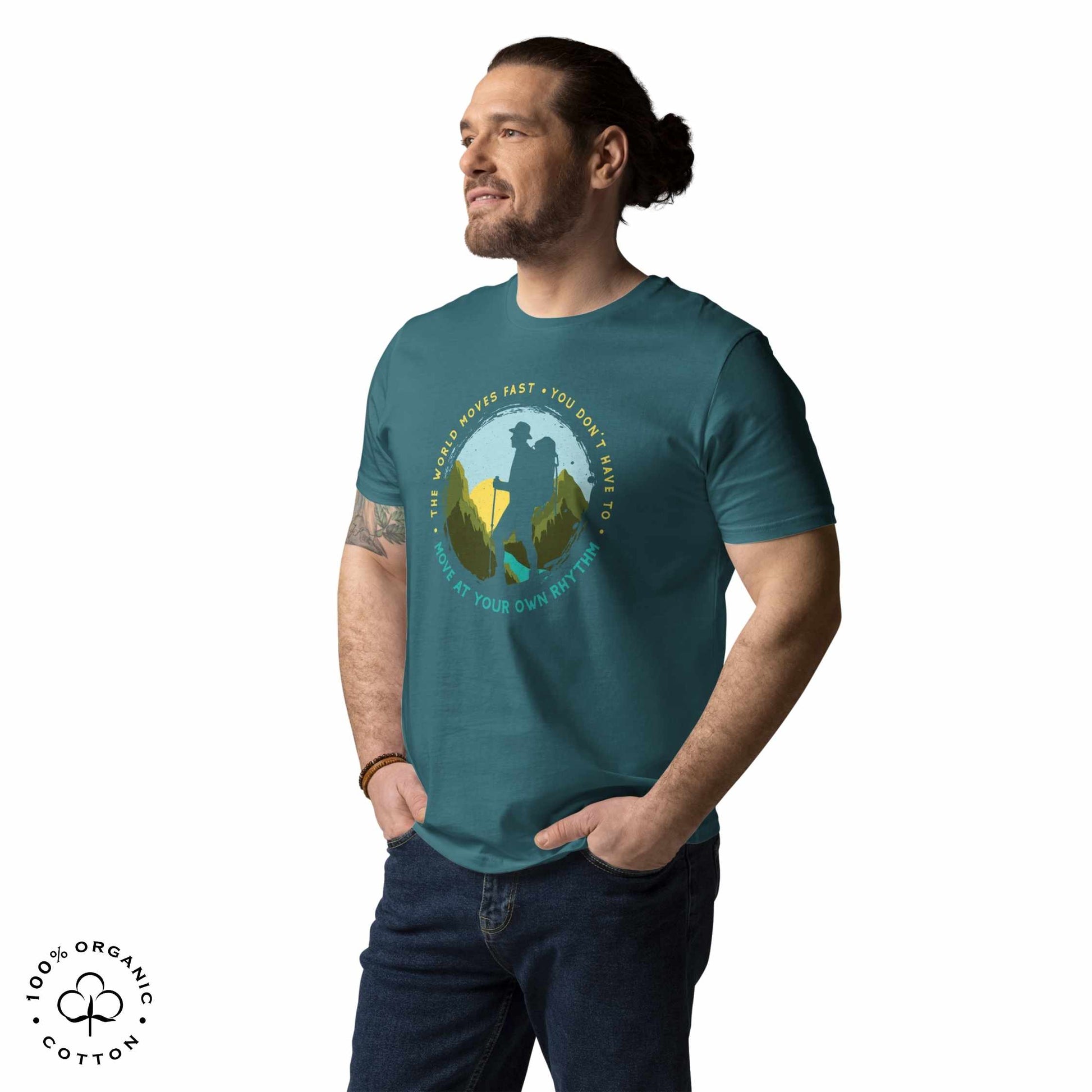 Man wearing Stargazer green organic cotton t-shirt with a hiking graphic design and text "Move at your own rhythm" on a white background