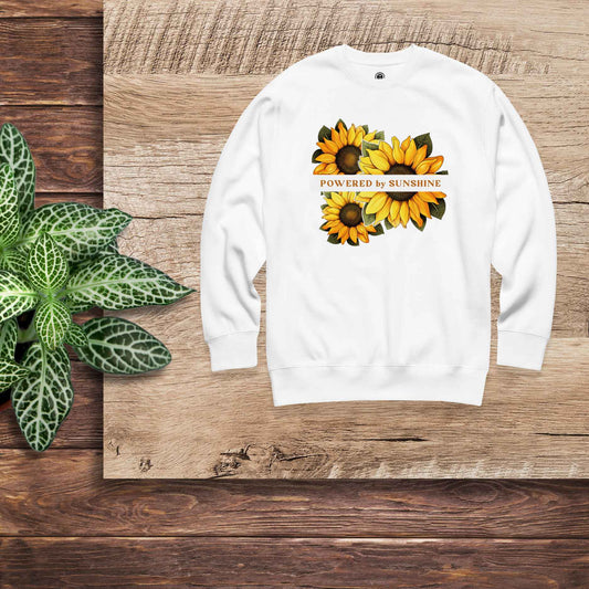 Woman sweatshirt with sunflower design and text Powered by Sunshine.