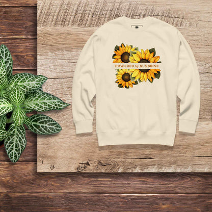 Woman sweatshirt with sunflower design and text Powered by Sunshine.