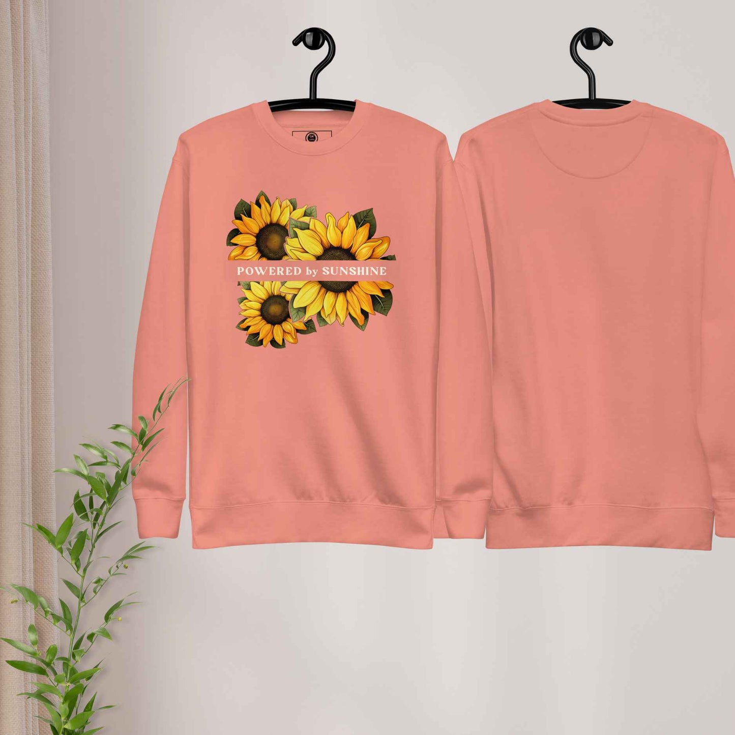 Woman sweatshirt with sunflower design and text Powered by Sunshine.