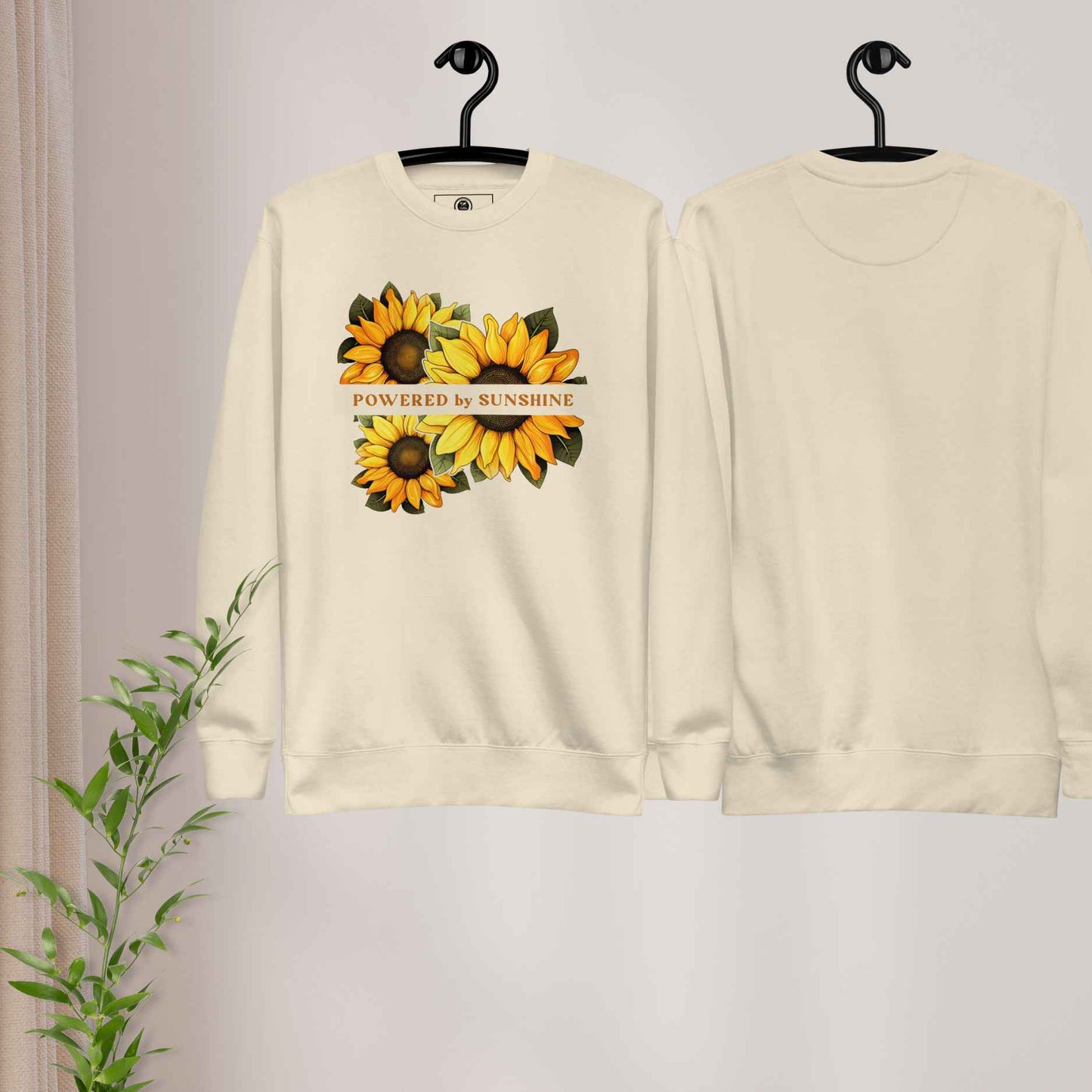 Woman sweatshirt with sunflower design and text Powered by Sunshine.