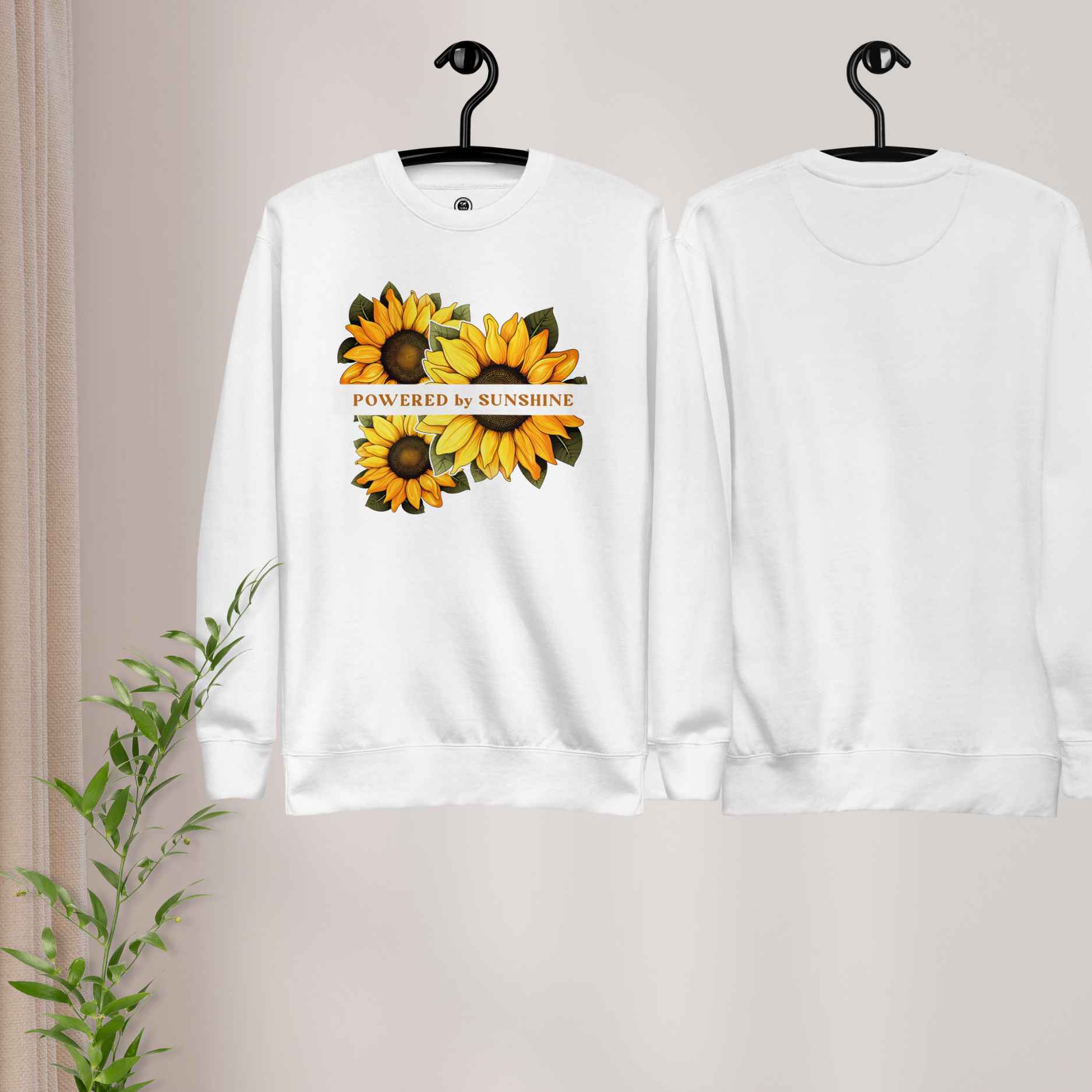 Woman sweatshirt with sunflower design and text Powered by Sunshine.