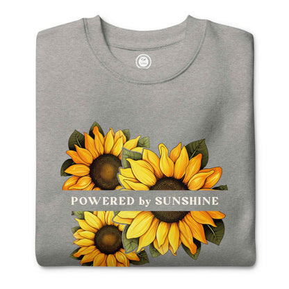 Woman sweatshirt with sunflower design and text Powered by Sunshine.