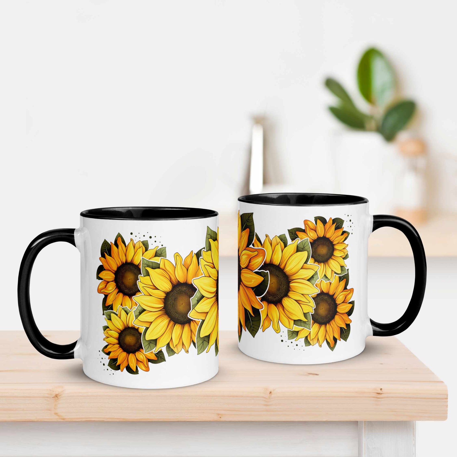 Two white mugs with black handles featuring sunflower designs on a wooden surface.