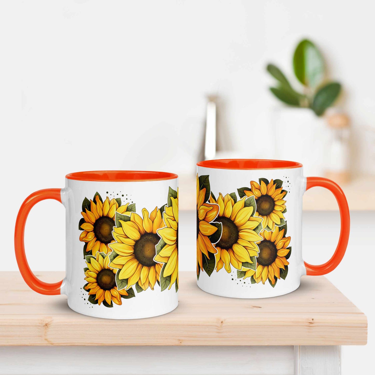 Two mugs with sunflower design and orange handles on a wooden surface.