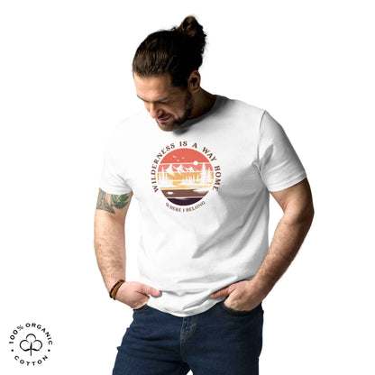 Man wearing Eco-friendly t-shirt in organic cotton, white, with graphic featuring a nature theme: mountains, trees, sun and the bold phrase “wild nature is the way home, where I belong”.