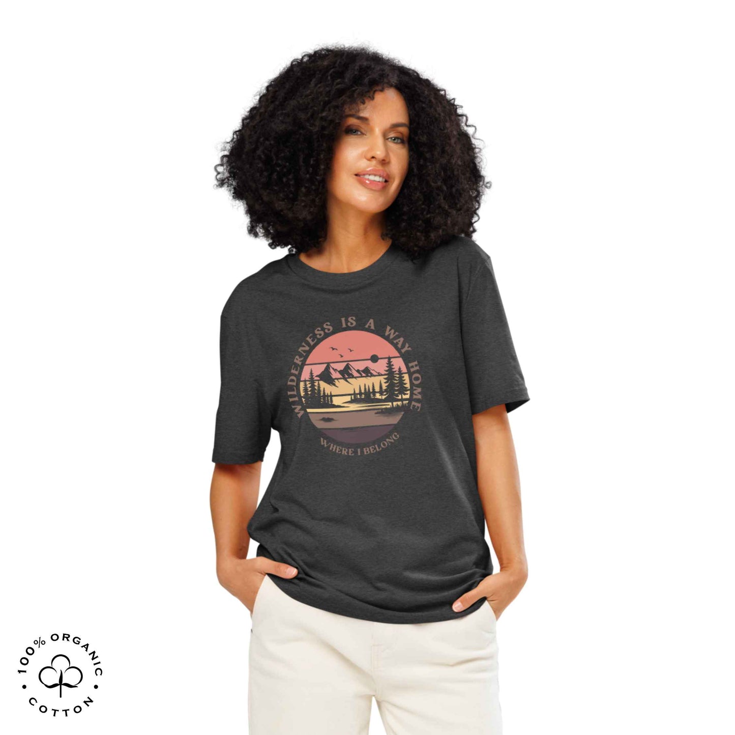 Woman wearing Eco-friendly t-shirt in organic cotton, dark grey, with graphic featuring a nature theme: mountains, trees, sun and the bold phrase “wild nature is the way home, where I belong”.