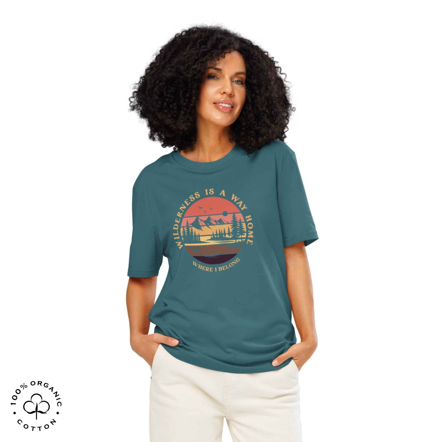 Woman wearing Eco-friendly t-shirt in organic cotton, stargazer, with graphic featuring a nature theme: mountains, trees, sun and the bold phrase “wild nature is the way home, where I belong”.